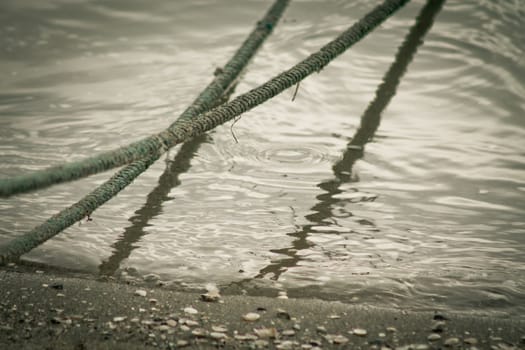 Hanging ropes reflected on water