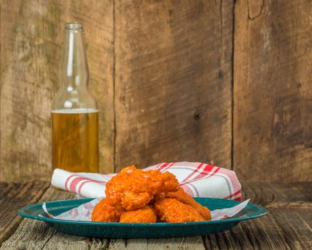 Spicy buffalo style chicken wings on a tin plate.