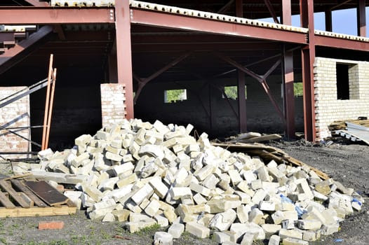 Construction materials and waste on the background of building under construction.