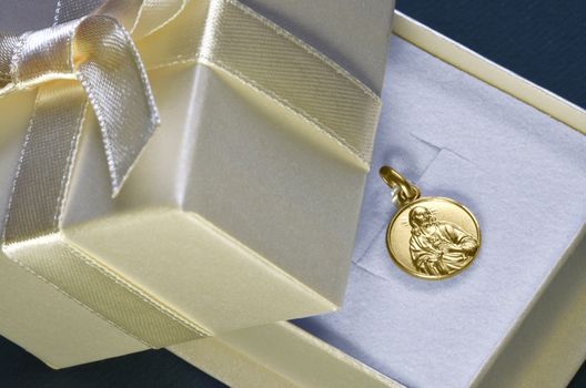 Religious gold pendant with Jesus showing heart. Typical gift for first communion for Catholics.