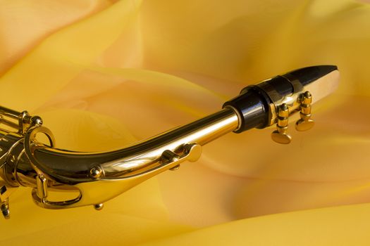 beautiful golden saxophone on delicate Yellow silk background
