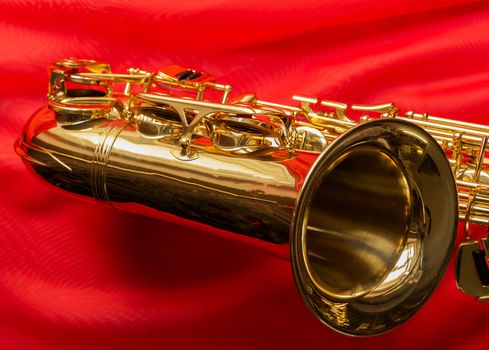 beautiful golden saxophone on delicate red silk background