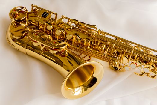 beautiful golden saxophone on delicate White silk background