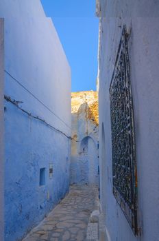 Oriental narrow street with blue houses in Medina, Hammamet Tunisia.