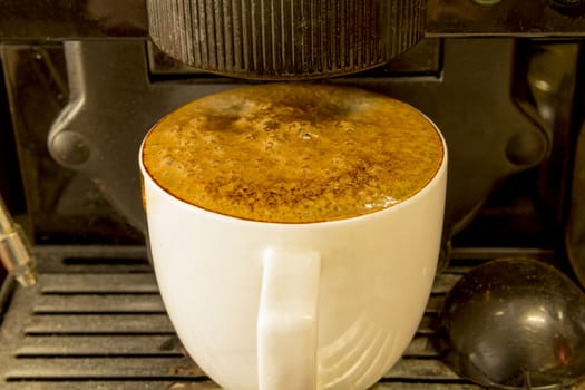 Black coffee in a white circle in the machine at home.