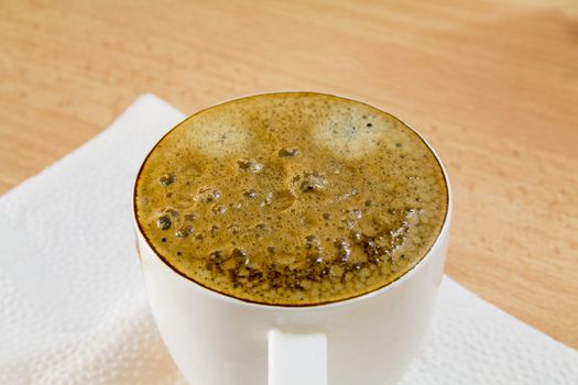 black coffee in a white circle on the table close-up
