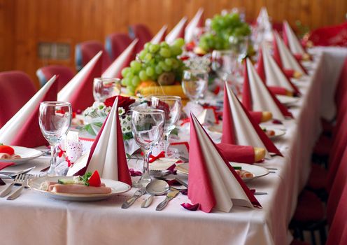 Wedding table covered by red table cloth.