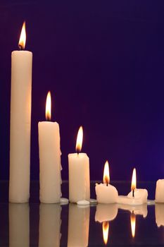 Set of lighting candles in a row on nice dark background