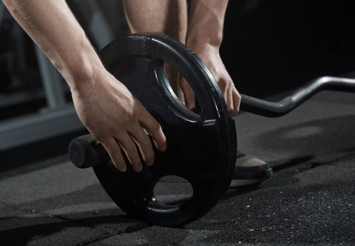 Man preparing barbell at fitness club