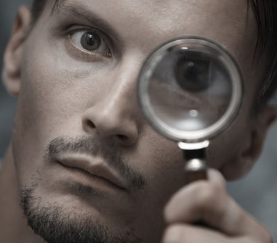 Man with magnifying glass. Horizontal portrait