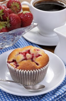 Muffin filled with strawberries on a table  cup of coffee