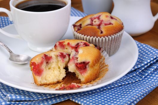 Break muffin with strawberries on a table cup of coffee