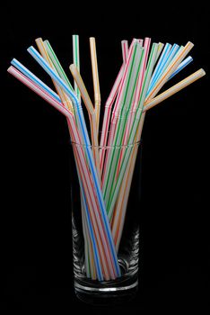 Color straw in glass isolated on the black background.