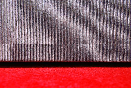 Detail of red carpet and grey sofa.