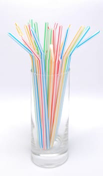 Color straw in glass isolated on the white background.