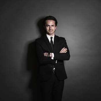 Portrait of businessman in suit on dark background