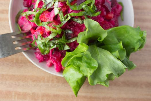 healthy salad, beet, fork on wooden table
