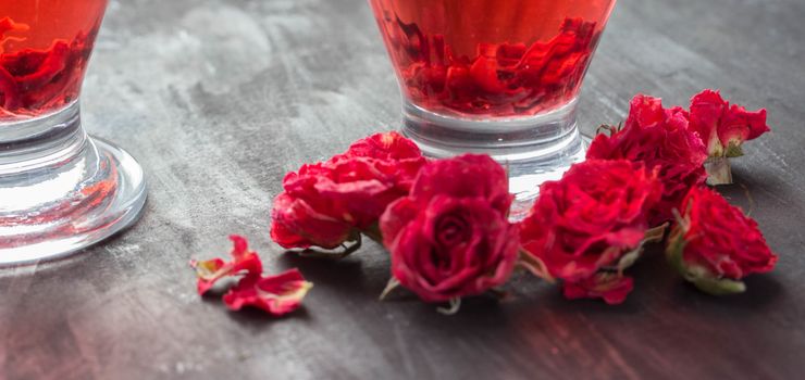 red drink and roses on dark background