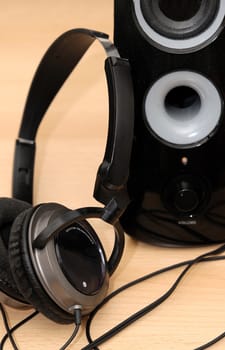 Black design headphones rest against the loudspeaker.