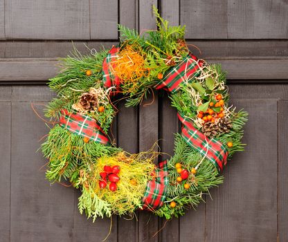 Nice Christmas wreath hanged on the wood door.