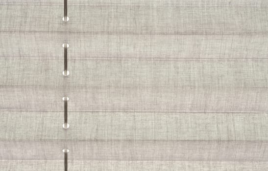 Closeup image of gray fabric blind on the window.