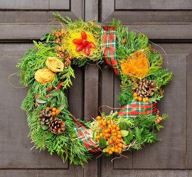 Nice Christmas wreath hanged on the wood door.