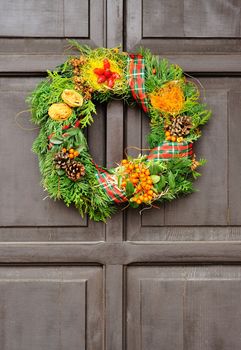 Nice Christmas wreath hanged on the wood door.