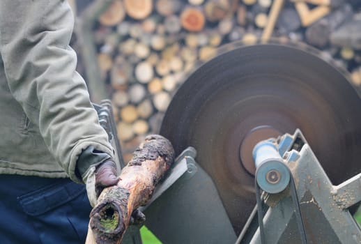 Man sawing wood on the circular saw.