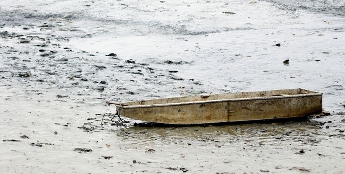 View to the old dirty fishing boat in drained pond.