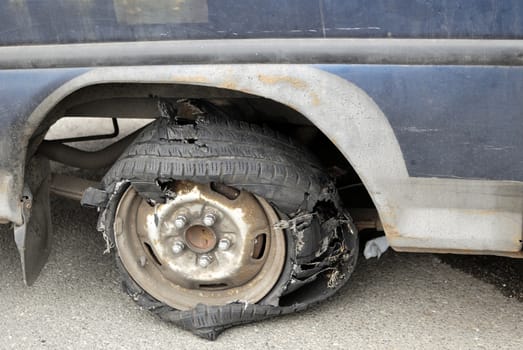 Close-up image of torn tyre on old car.