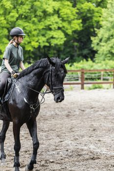 girl sportsman rides on horse training outdoors