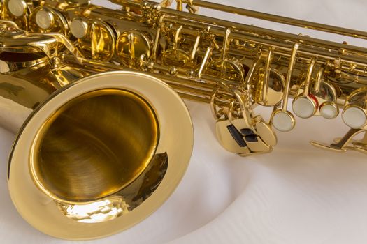beautiful golden saxophone on delicate White silk background