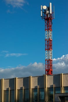 Red and white antenna tower on the roof of the building.