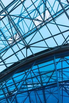 Bottom view of modern glass roof in business district in evening.