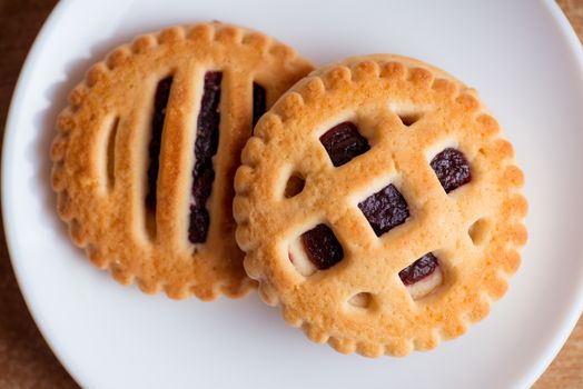 cookies with jam in saucer on table top view.