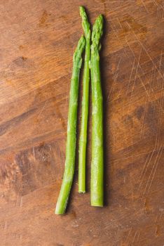 Frozen sticks of asparagus on rustic wood background. horizontal view