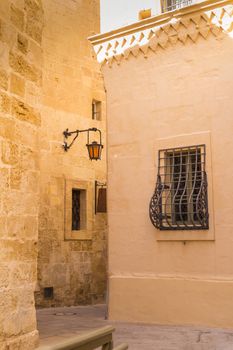 Fusion of arabian and baroque architecture in the former capital of island Malta - Mdina, medieval fortress. Stone houses , yellow color in the sunlight.