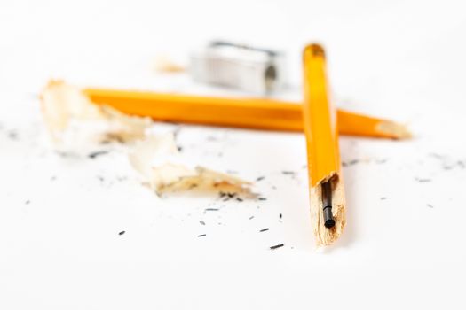 Pencil, metal sharpener and pencil shavings on white background. Horizontal image.