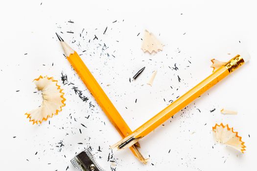 Pencil, metal sharpener and pencil shavings on white background. Horizontal image.