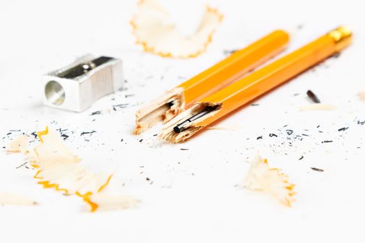 Pencil, metal sharpener and pencil shavings on white background. Horizontal image.