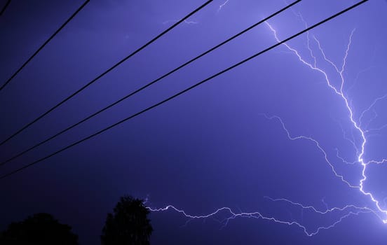 Night shot with bolt and power lines.