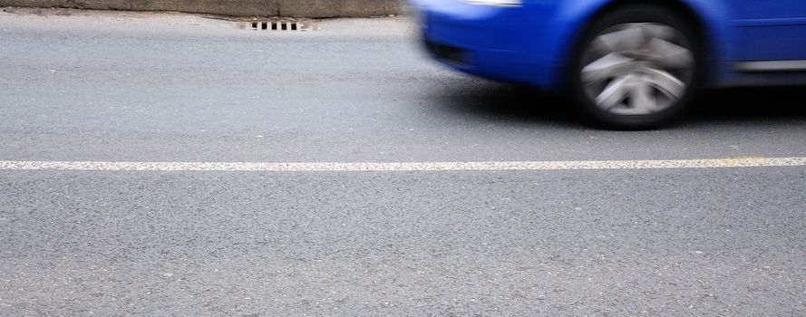 Closeup shot of blue moving car.