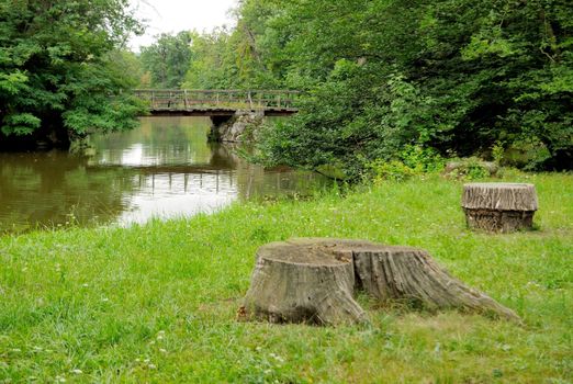 Secluded place in parkland with river and bridge in the back.