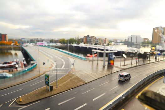 Tilt shift image of city with car on the street.