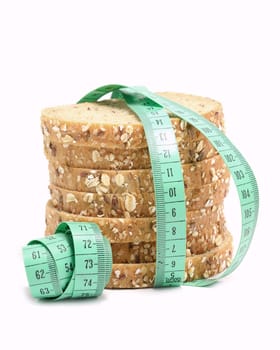 Fresh multigrain bread tied by green measuring tape - diet doncept.