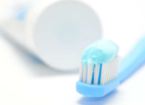 Macro shot of toothbrush and toothpaste on the white background.