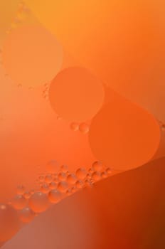 Abstract red, orange background from floating oil bubbles in the water.