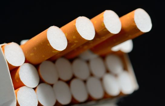 Closeup shot of white pack of cigarettes on a black background.