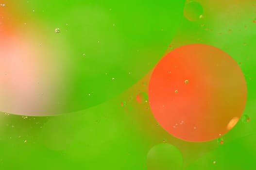 Abstract green background from floating oil bubbles in the water.