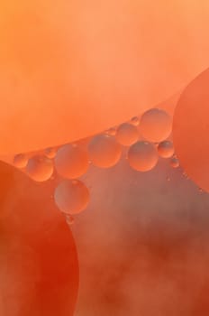 Abstract red, orange background from floating oil bubbles in the water.